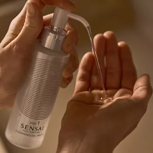 Close up of person dispensing Silky Purifying Cleansing Gel Water from bottle to hand 
